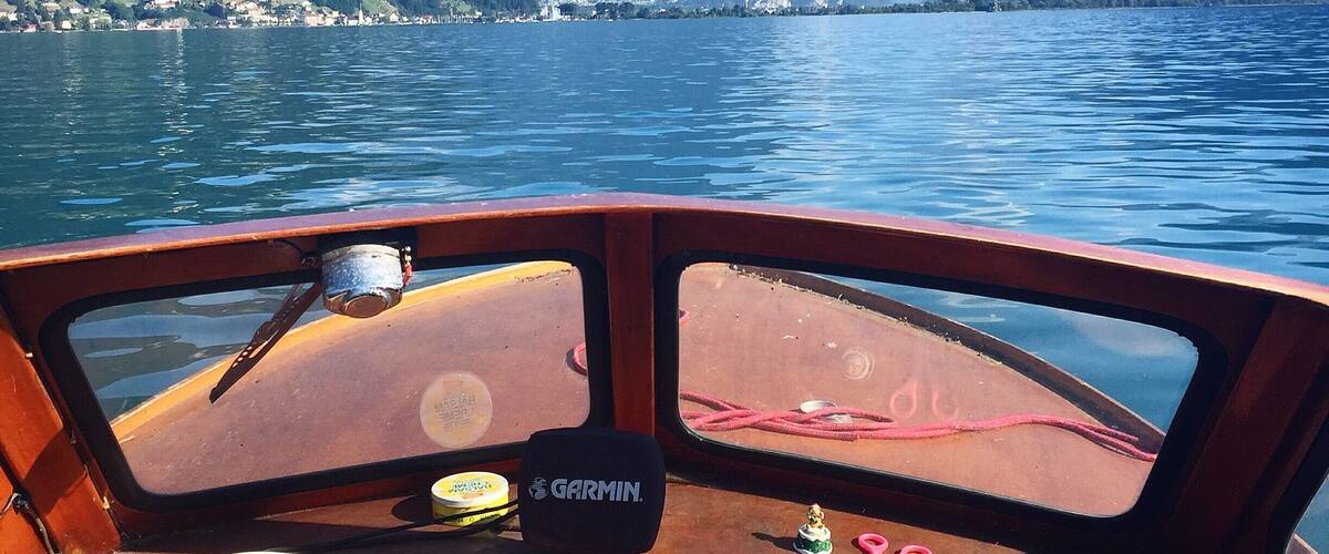 A boat's interior with a view of a lake and mountains.