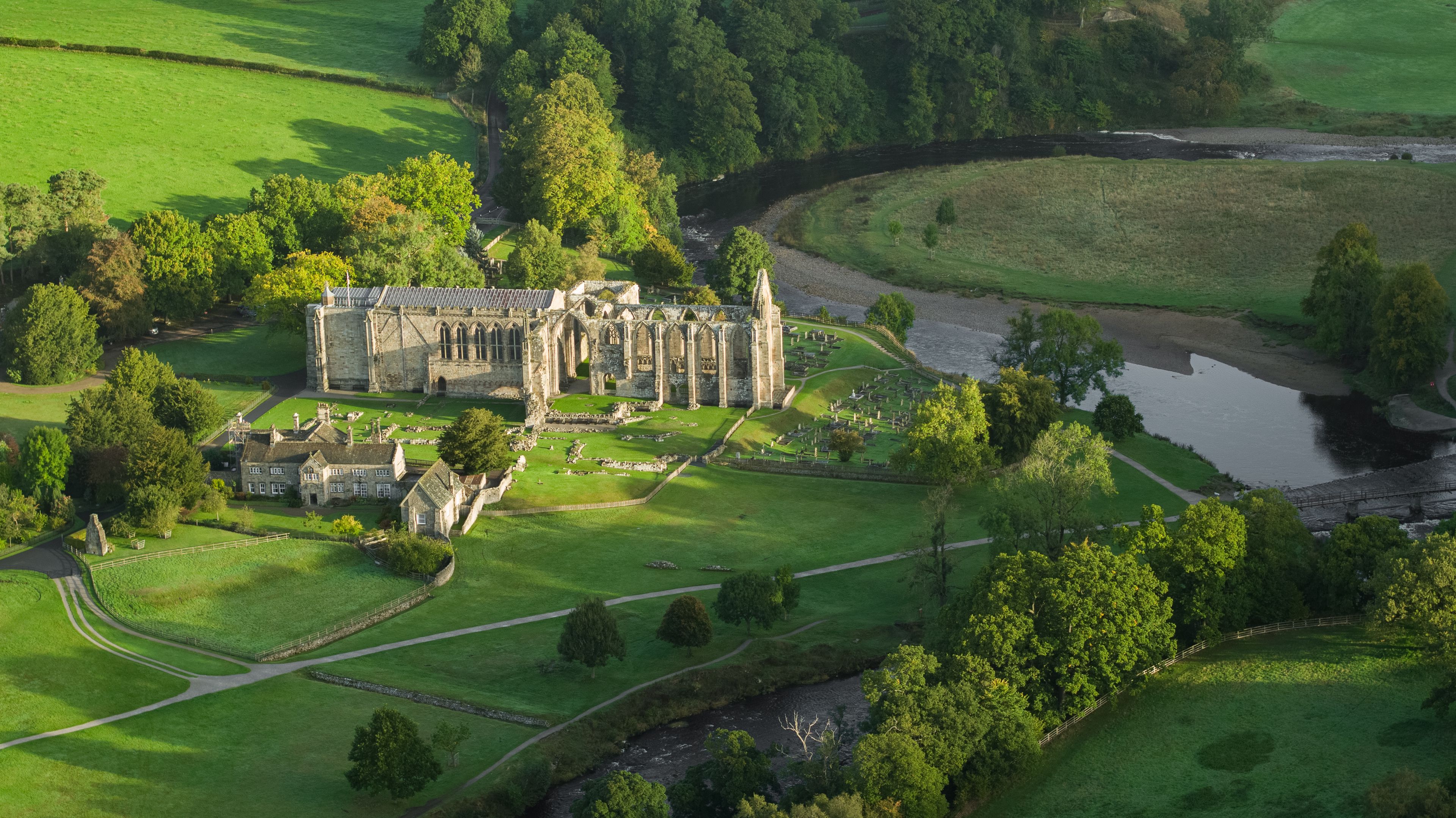 A historic castle surrounded by lush green fields and a river.