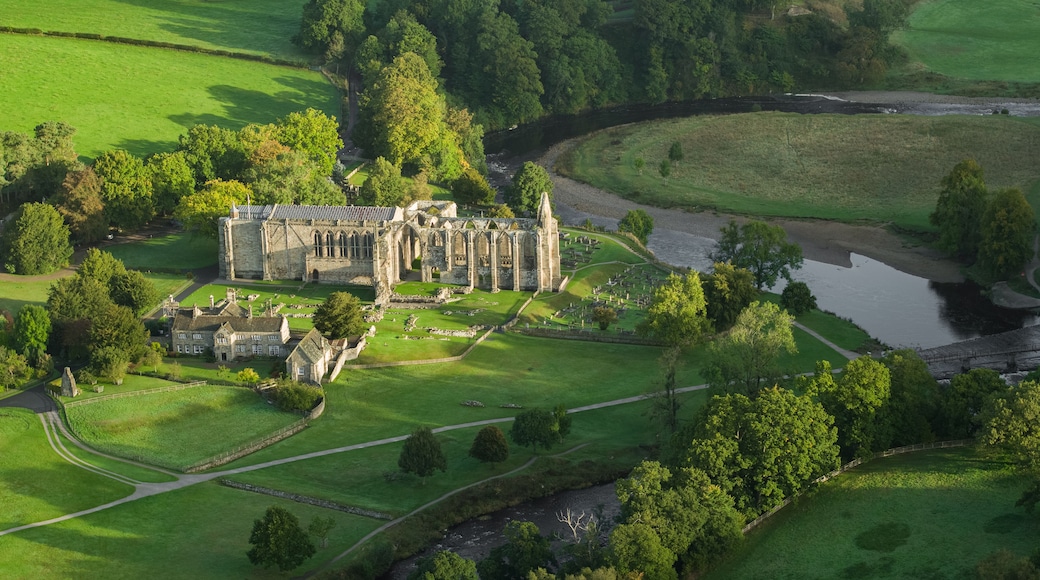A historic castle surrounded by lush green fields and a river.