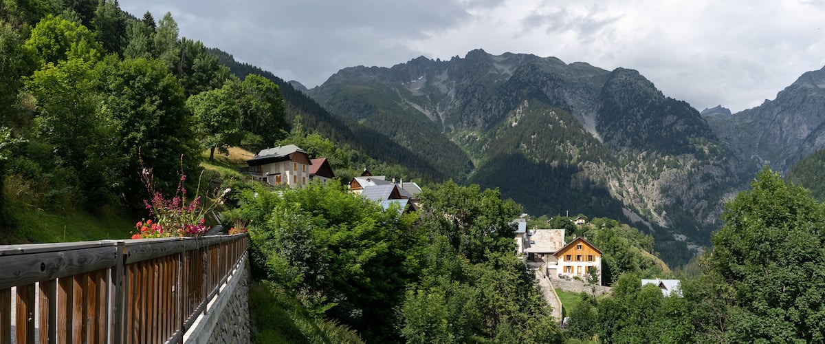 A mountainous landscape with houses nestled among lush greenery.