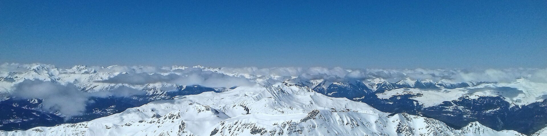 A snow-covered mountain range with clear skies.