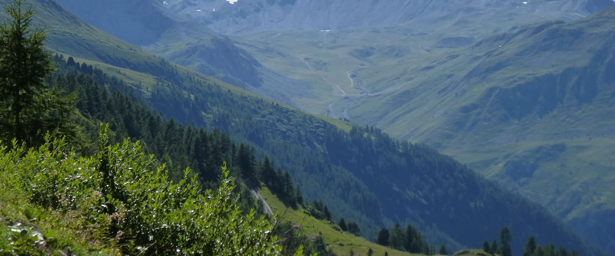 A mountain range with snow-capped peaks and lush green valleys.