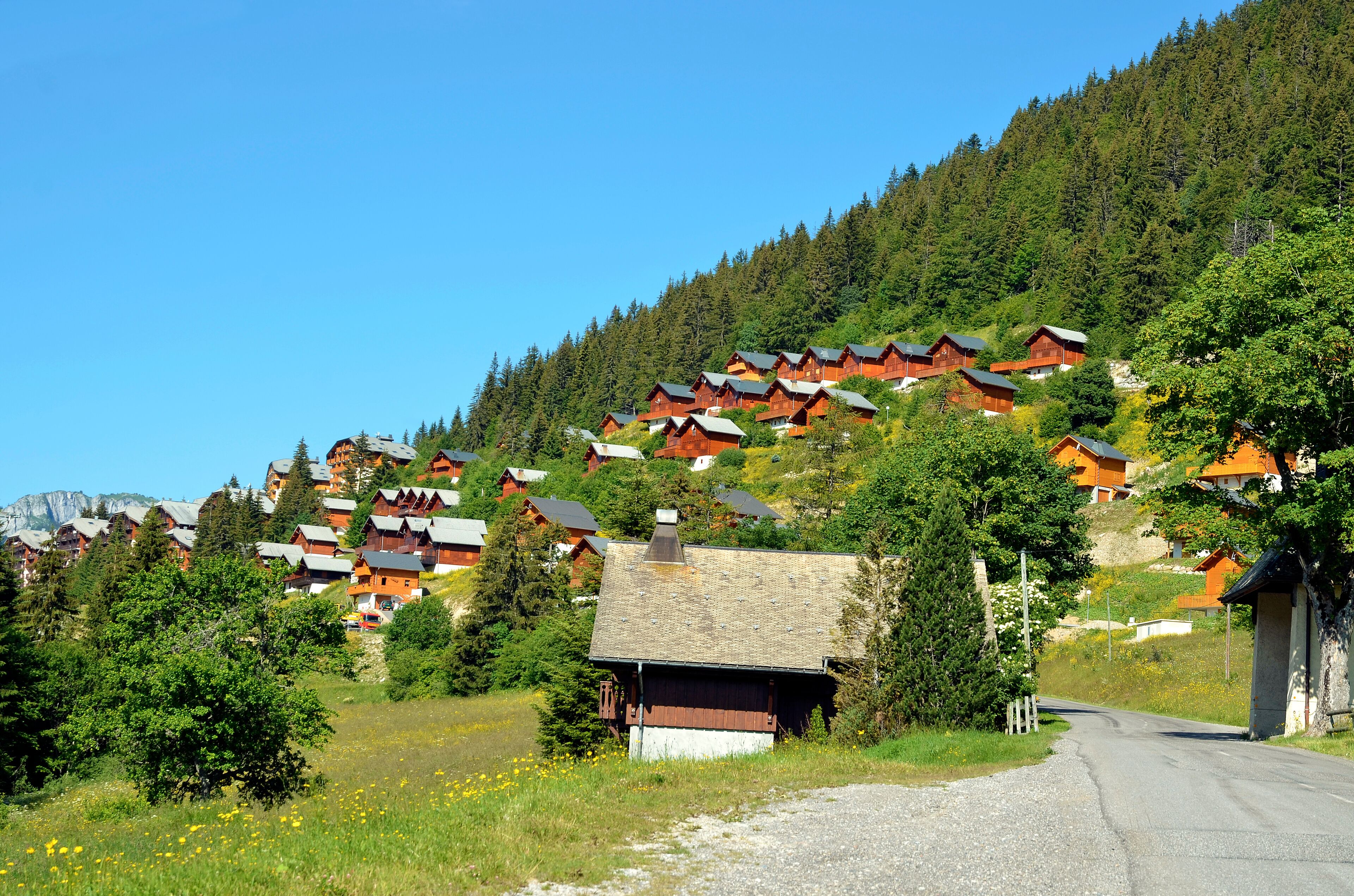 A hillside village with wooden houses and a clear blue sky.