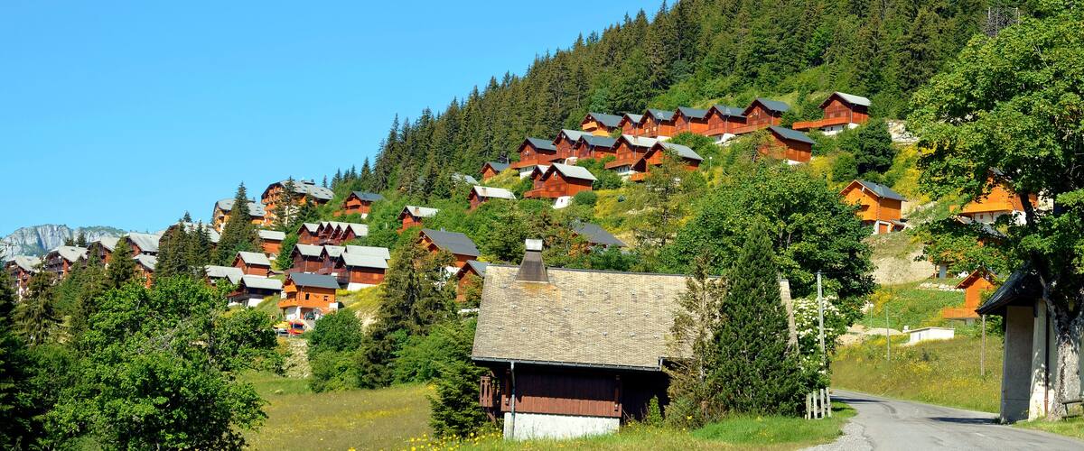 A hillside village with wooden houses and a clear blue sky.