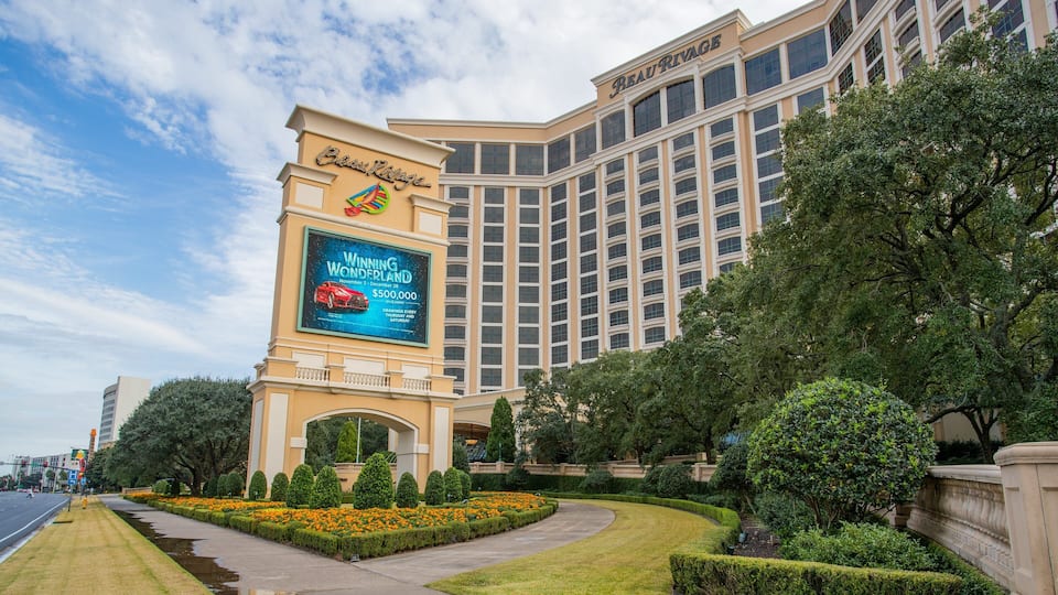 A large hotel with a prominent billboard advertising a car giveaway.