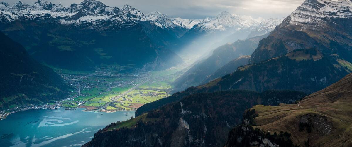 sun rays shining into Reussebene with Altdorf, Flüelen, Schattdorf, Gross Windgällen, Bristen and Urnersee