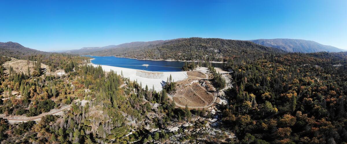 A lake surrounded by forested mountains.
