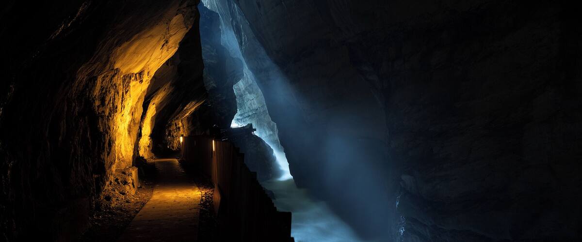 A narrow passageway with a staircase leading up, surrounded by ice formations.