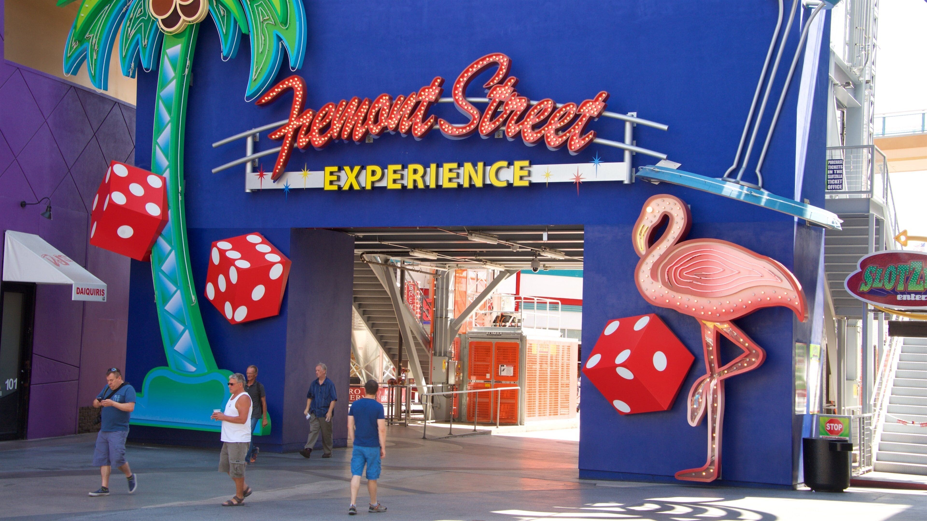 Fremont Street featuring signage as well as a small group of people
