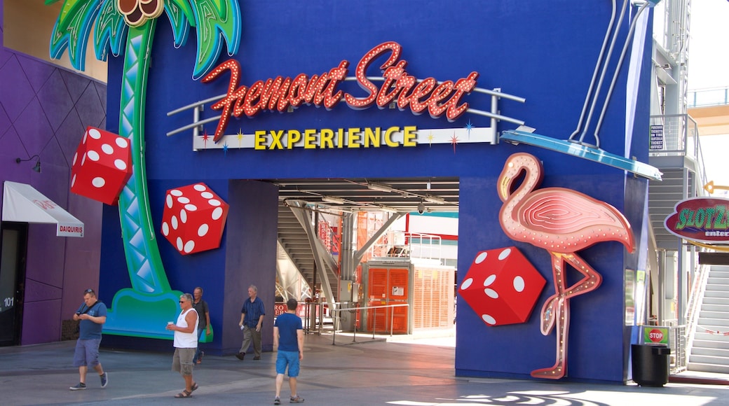 Fremont Street featuring signage as well as a small group of people