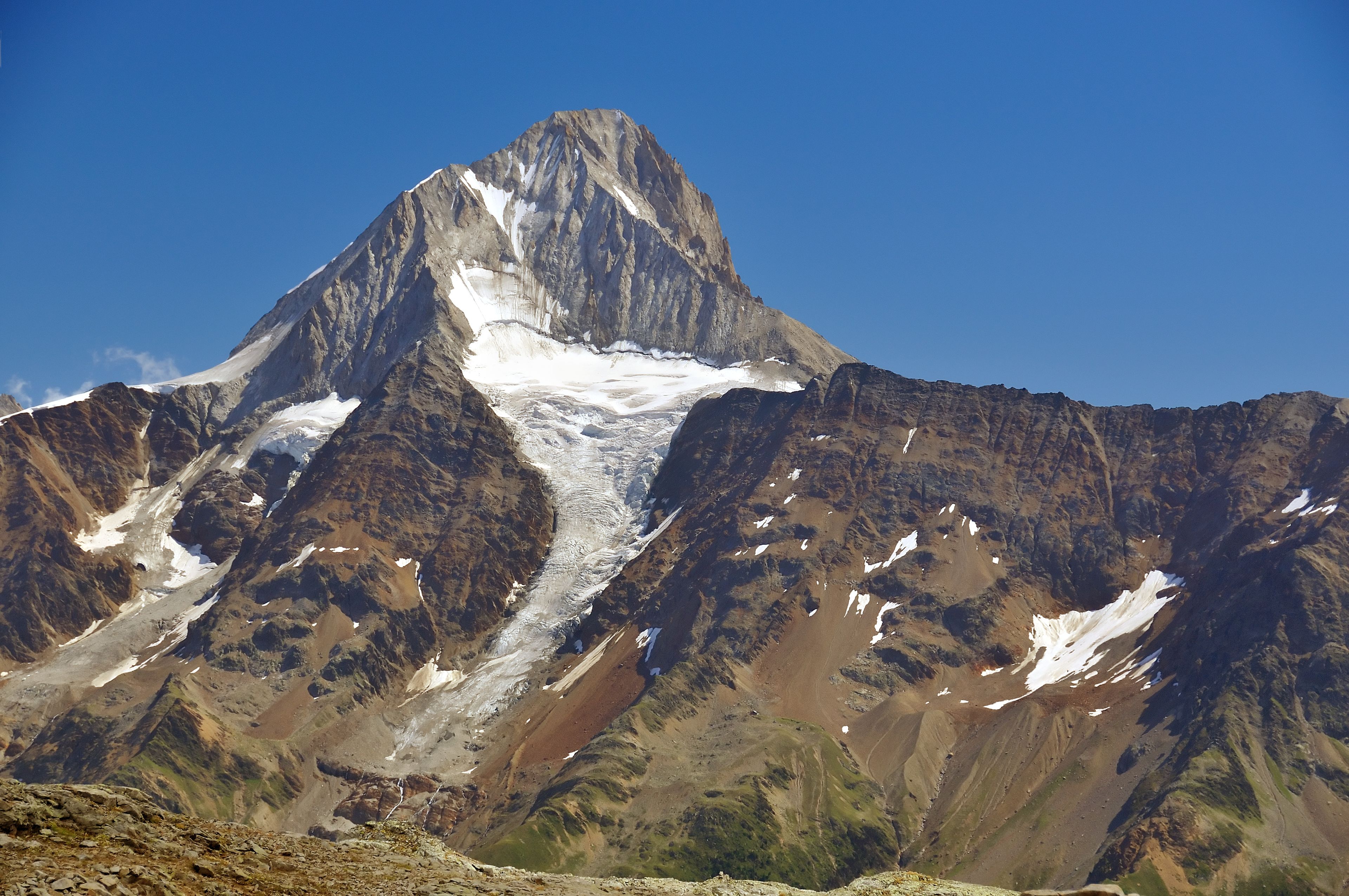 Un sommet montagneux enneigé, surmonté d’un glacier.