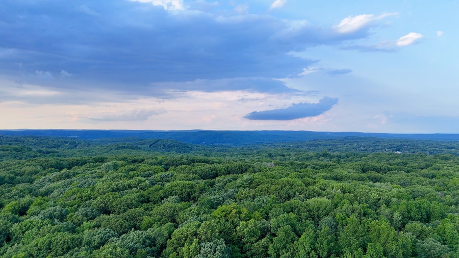 Stormy Drone photo above the green forest in rural Connecticut. Summer aerial photo of Harwinton, CT.