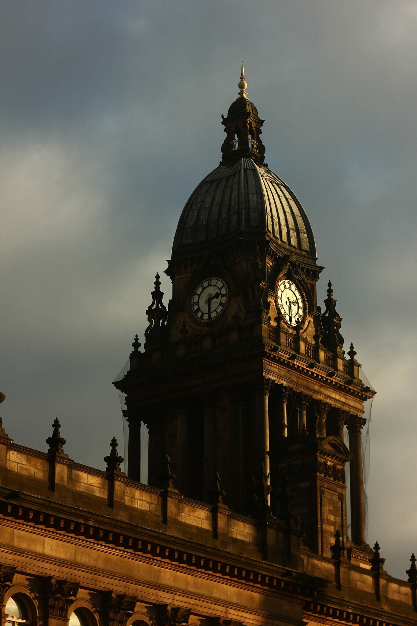 500px provided description: This photo was taken on a evening photo-walk through Leeds. It highlights how dramatic buildings in the North look under proper light and takes you back to gothic architecture. I particularly love the colours and contrast of this picture. It was achieved with Helios (old-school soviet lens) I inherited from my father (who did photography) and which I keep as a dear reminder. [#tower ,#outdoor ,#roof ,#building ,#evening ,#clock ,#dramatic]