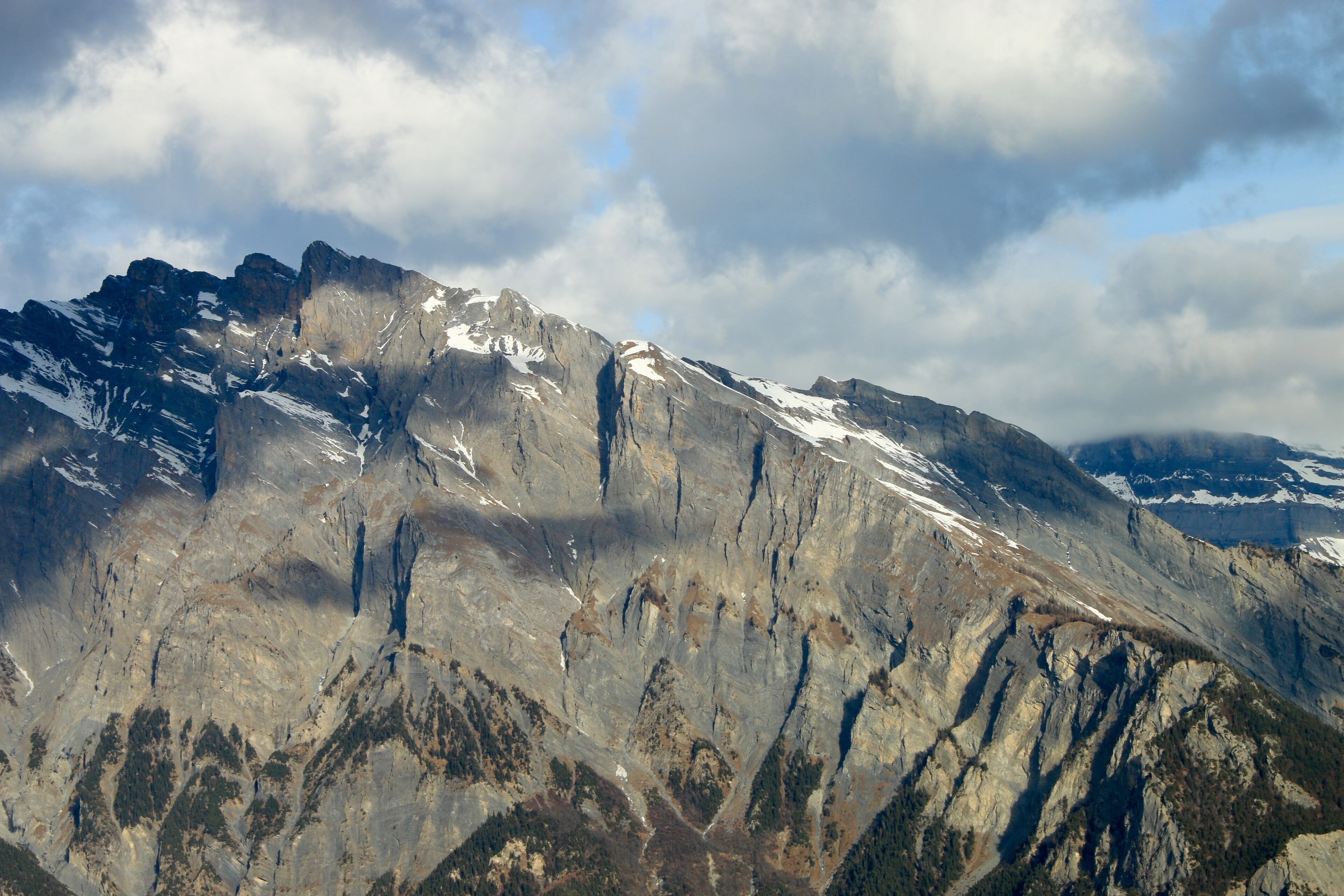 A rugged mountain range with snow-capped peaks and deep valleys.