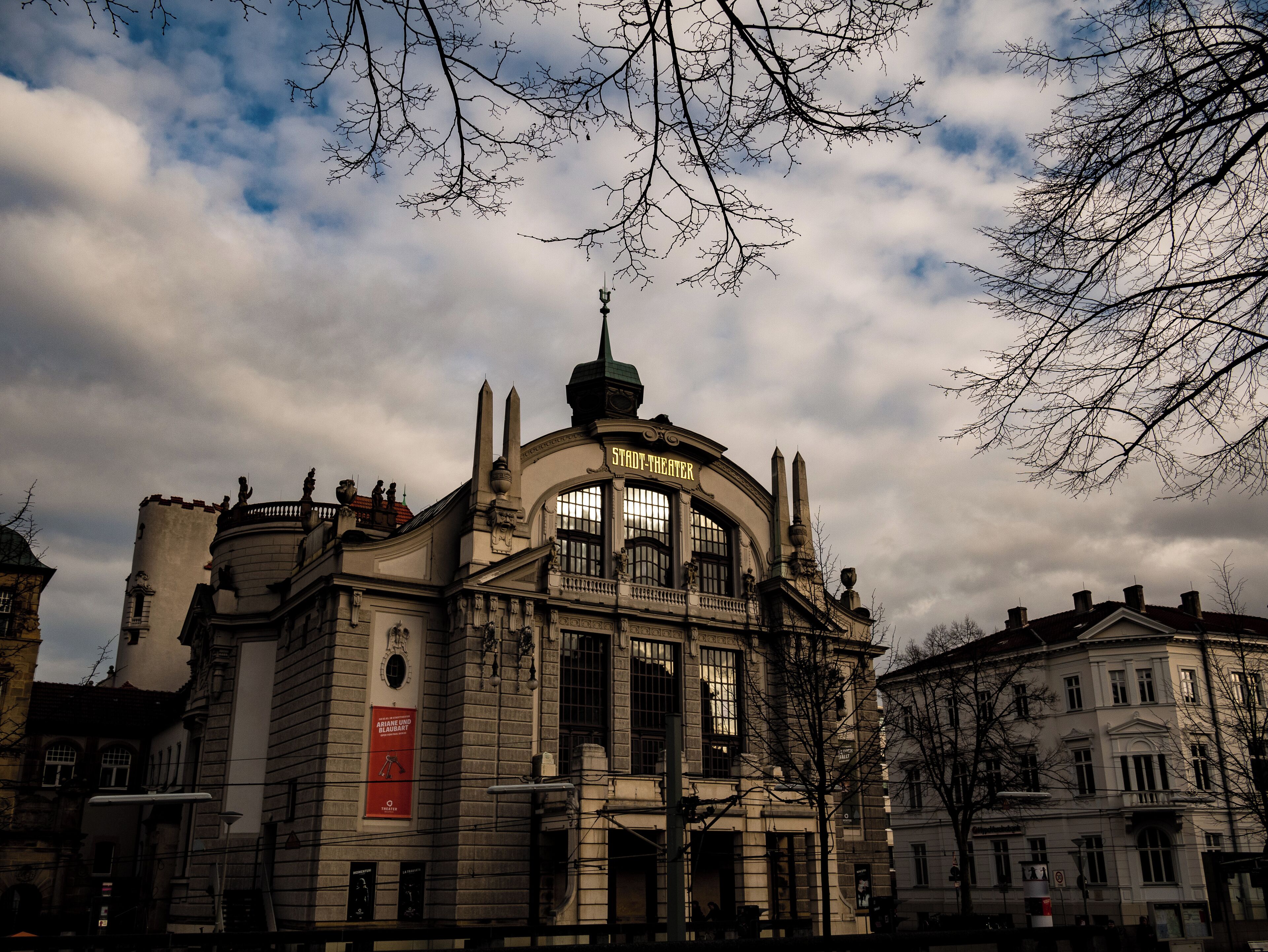 Un edificio histórico de teatro con arquitectura ornamentada y un letrero llamativo.