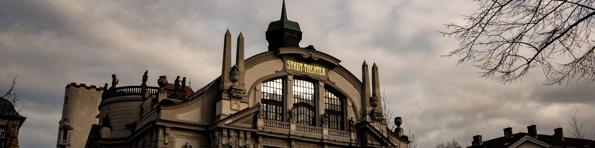 Un edificio histórico de teatro con arquitectura ornamentada y un letrero llamativo.
