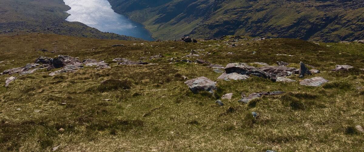 A mountainous landscape with a lake and rocky terrain.