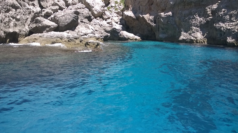 A clear blue sea with rocky cliffs.