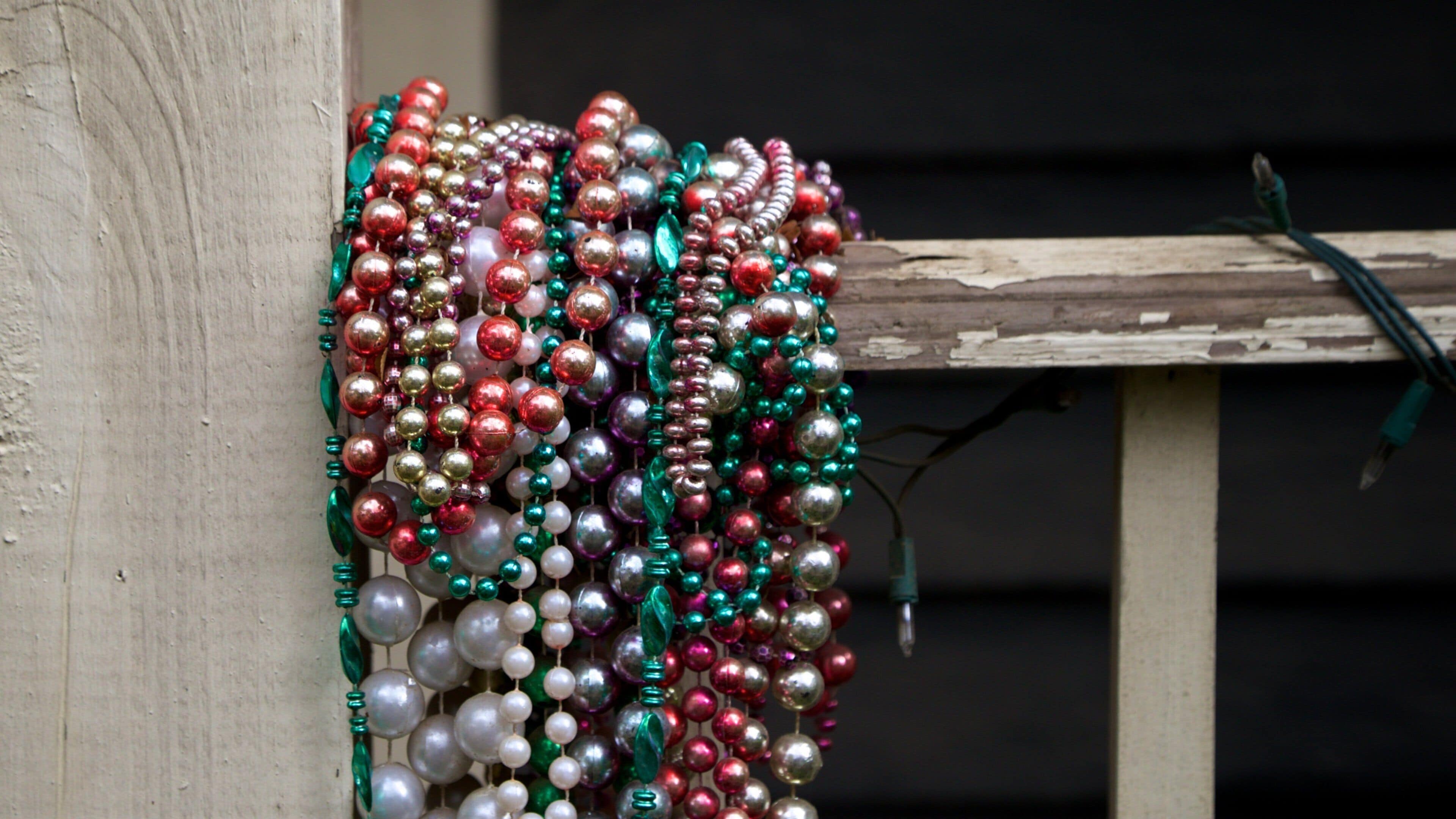 A wooden fence with colorful beads and a green wire.