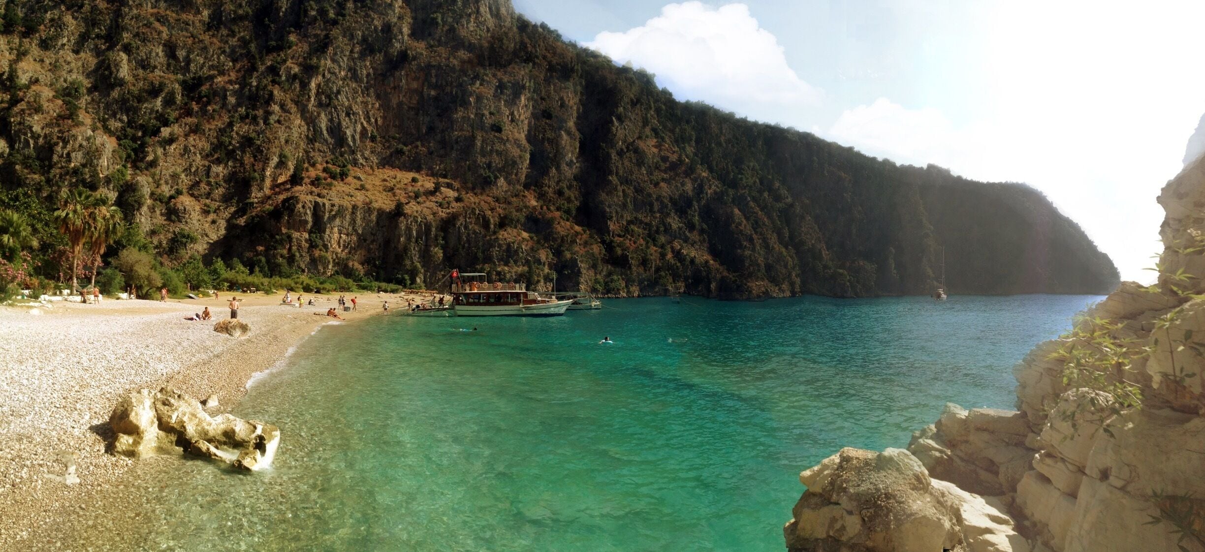Butterfly Valley (Turkish: Kelebekler Vadisi) is a valley in Fethiye district of Muğla Province, southwestern Turkey, which is home to diverse butterfly species.
The valley is situated at the foothill of Babadağ, a 1,975 m (6,480 ft)-high mountain nominated for preservation as world heritage. A wide-strip sand beach at a bay on the Turkish Riviera protrudes from the valley. In the form of a narrow canyon stretching over around 3–4 km (1.9–2.5 mi), the valley's steep walls are 350–400 m (1,150–1,310 ft) high. A trail in the valley leads to two small waterfalls dropping from 60 m (200 ft) all the year around. In the middle of the valley, a creek runs, carrying water from a spring in nearby Faralya village to the sea. A road from Ölüdeniz to Uzunyurt, which is part of the Lycian Way Ultramarathon route, runs atop the rocks around the valley