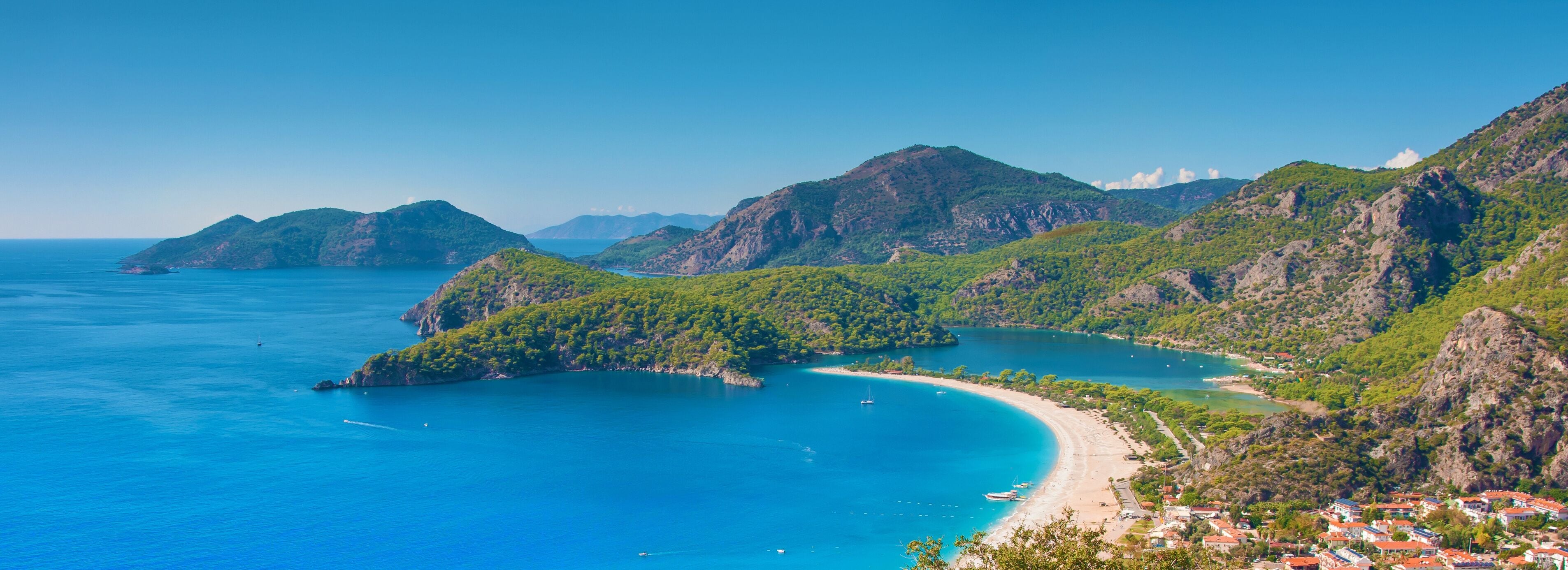 Eine Küstenlandschaft mit einer Bucht, einem Strand und einem Dorf.