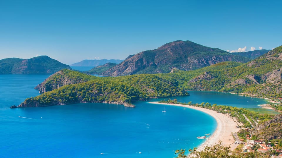 Paisagem costeira com uma baía, uma praia e uma vila.