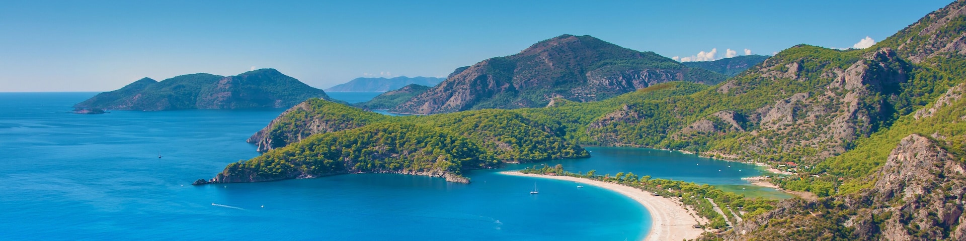 A coastal landscape with a bay, a beach, and a village.
