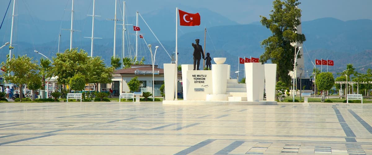 Un monument comprenant un drapeau, une statue et un bâtiment avec une enseigne.