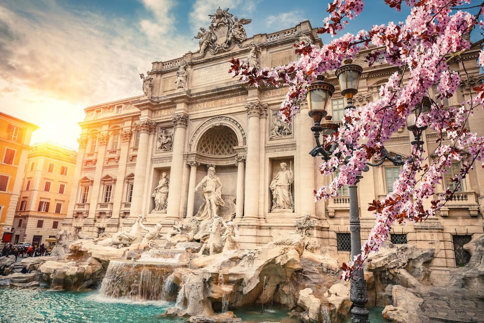 The Trevi Fountain with sculptures and a large archway.