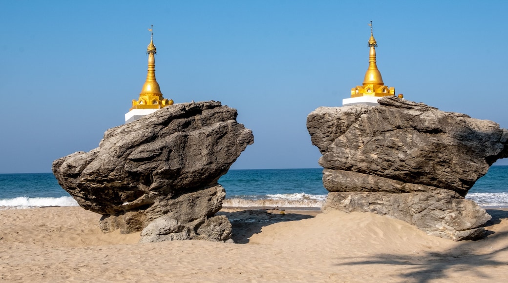 Zwei goldene Pagoden auf groĂen Felsen am Meer.