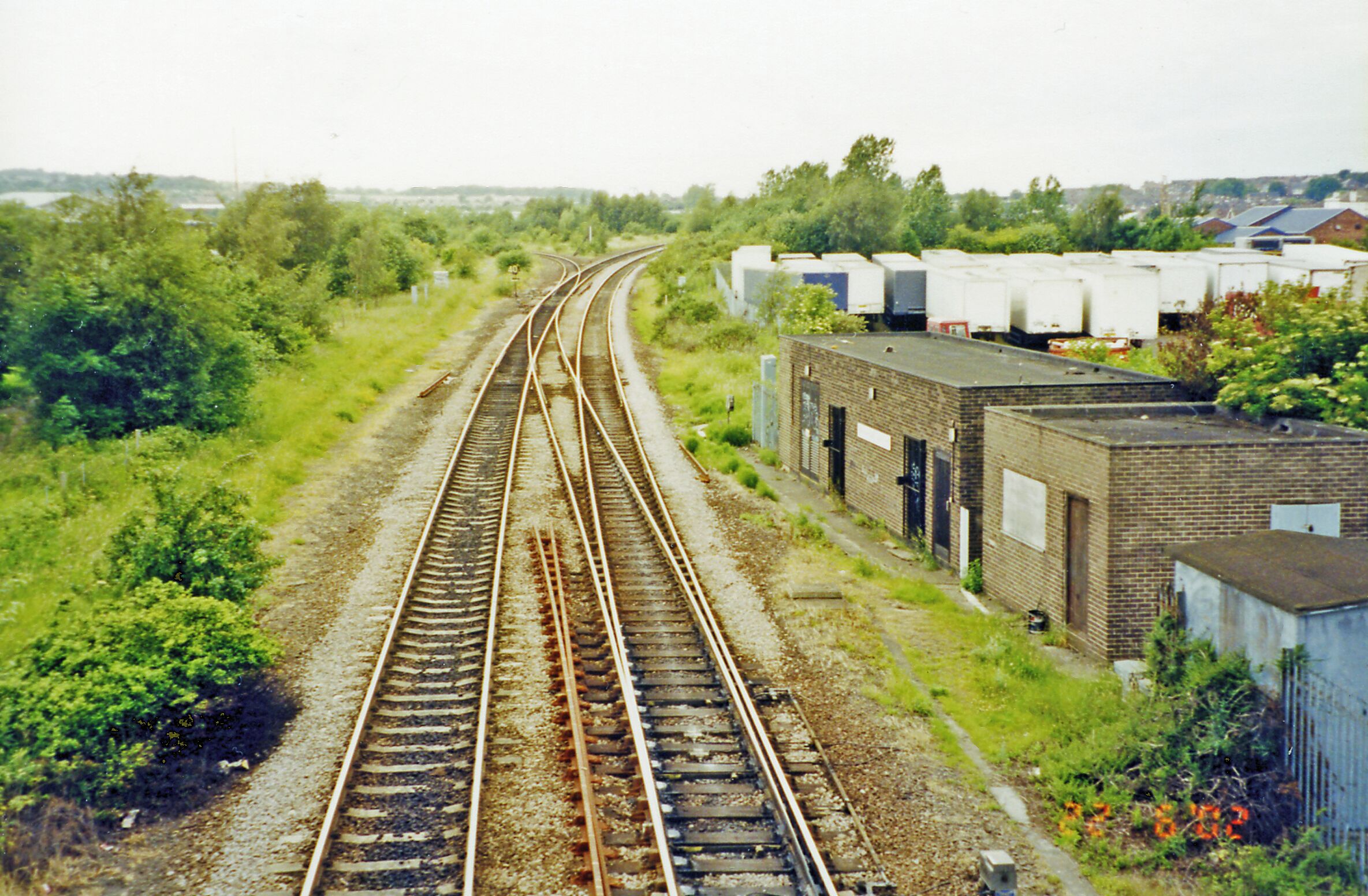 Mexborough No. 1 Junction, 2002. View westward from Mexborough station, intended to show the absence of Industry and Railway complexity in the 'Post-Industrial' 21st century. Mexborough station is now only a stop on the Sheffield - Doncaster route, which is the double-line, running onto the former ex-Midland Leeds - Sheffield (Midland) main line at Swinton (Midland). The single line branching off to the left connects with the now-abandoned ex-GC main line from the former Sheffield (Victoria). Fifty and more years ago, when these railways were immensely more complicated and conveyed enormous tonnages of coal, steel and other products of industry - as well as passengers, this point was on the GCR (LNER 1923-47) main lines from Manchester via Woodhead and Penistone (also Barnsley) to Doncaster, Scunthorpe, Grimsby and Cleethorpes: also just to the west of here traffic from York off the Swinton & Knottingley Line joined to go to Sheffield (Victoria) and the South. Just to the east of Mexborough station was a large locomotive depot, which provided motive-power for the immense freight traffic to and from the great Wath Marshalling Yard, about a mile west of this point