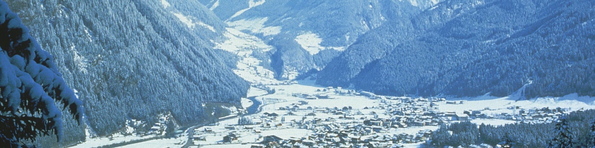 A snow-covered mountain town nestled between snow-capped peaks.