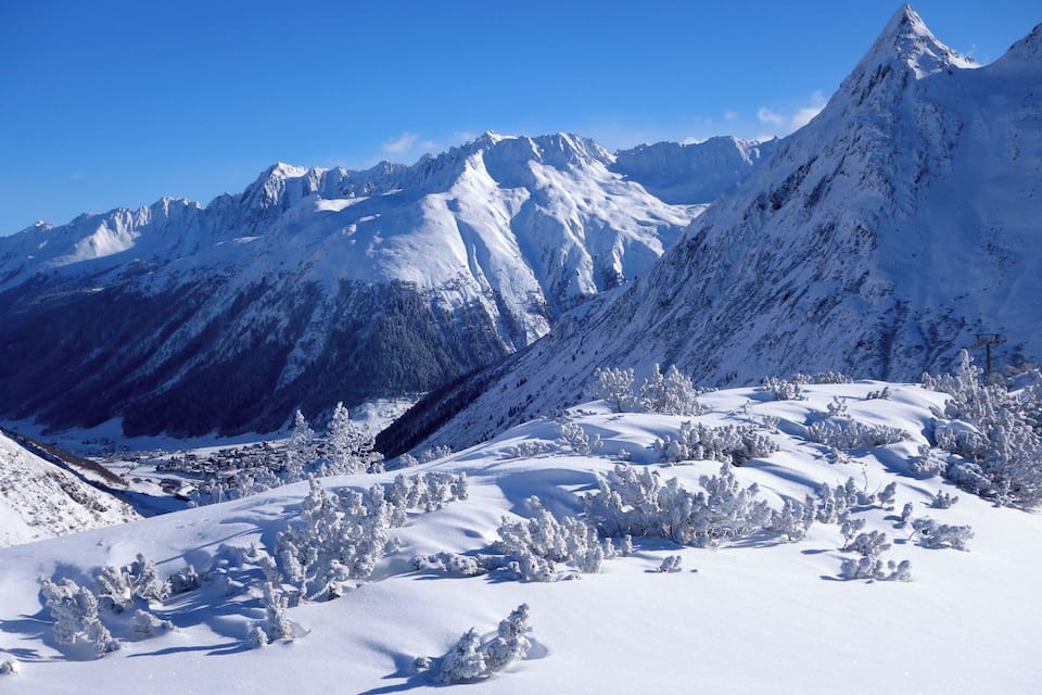 Een bergketen bedekt met sneeuw, met een helderblauwe lucht.