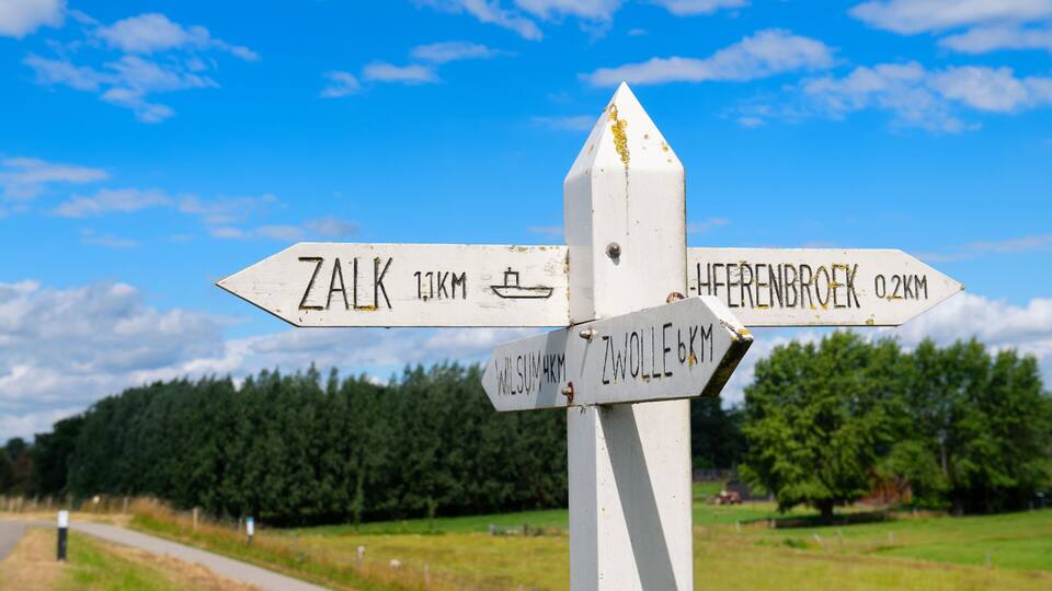 A directional signpost with arrows pointing to Zalk, Heffenbroek, and Zwolle.