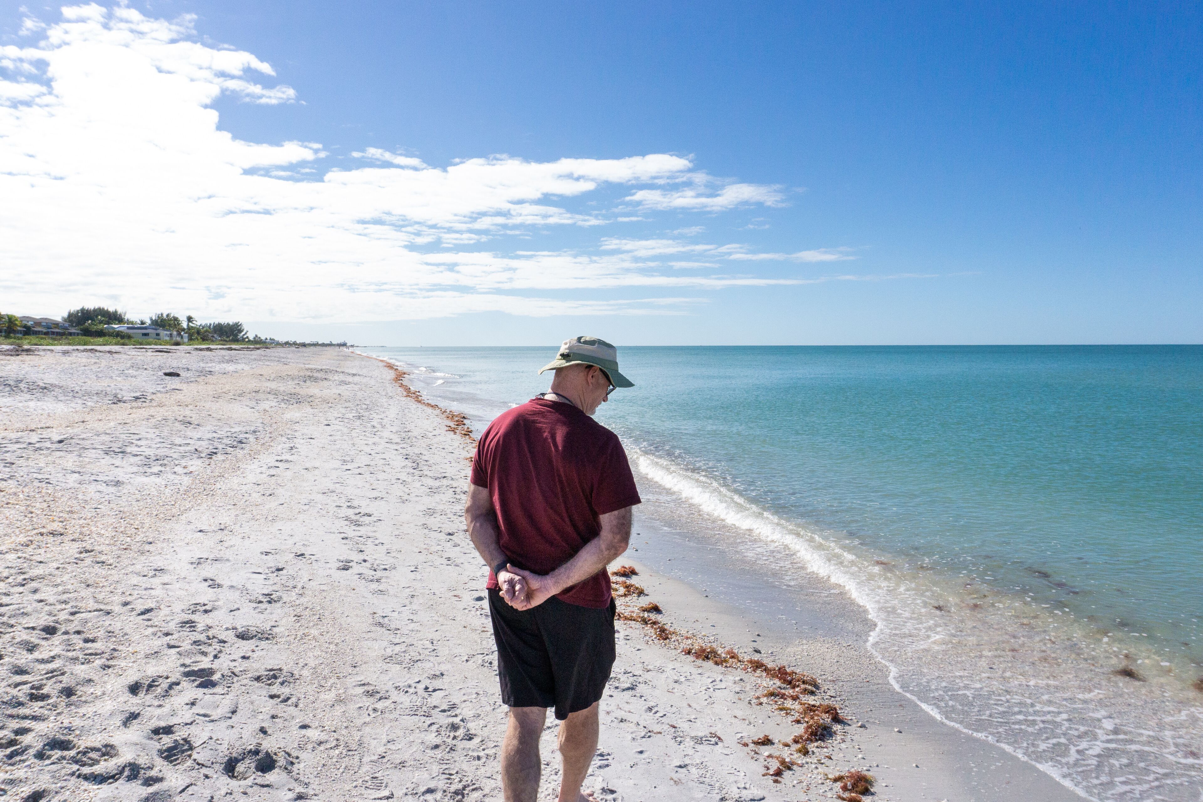 Retiree walks along tropical beach in Florida