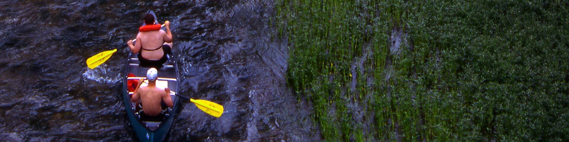 A river with a kayak and two paddlers.