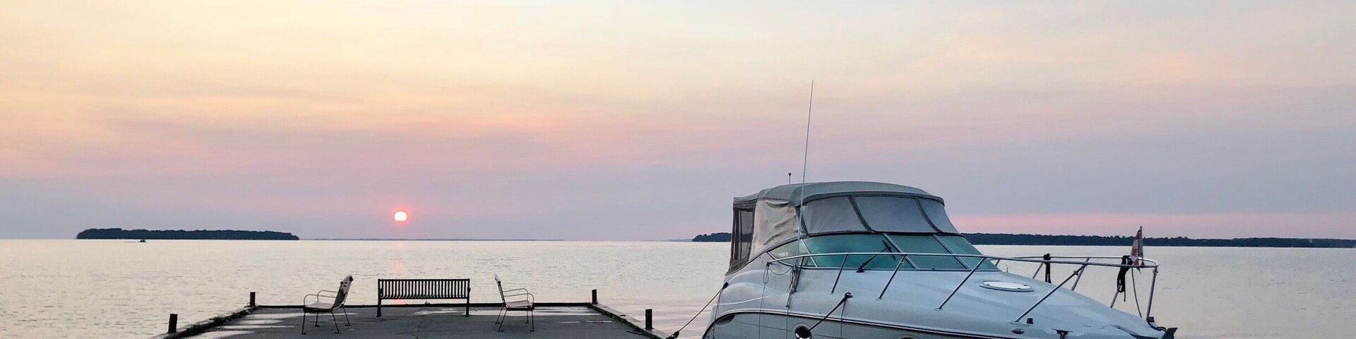 Un barco fondeado en un muelle al atardecer.