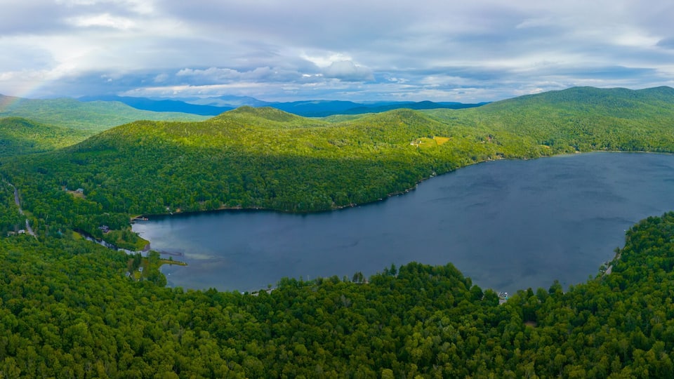 A lake surrounded by dense forest and mountains.