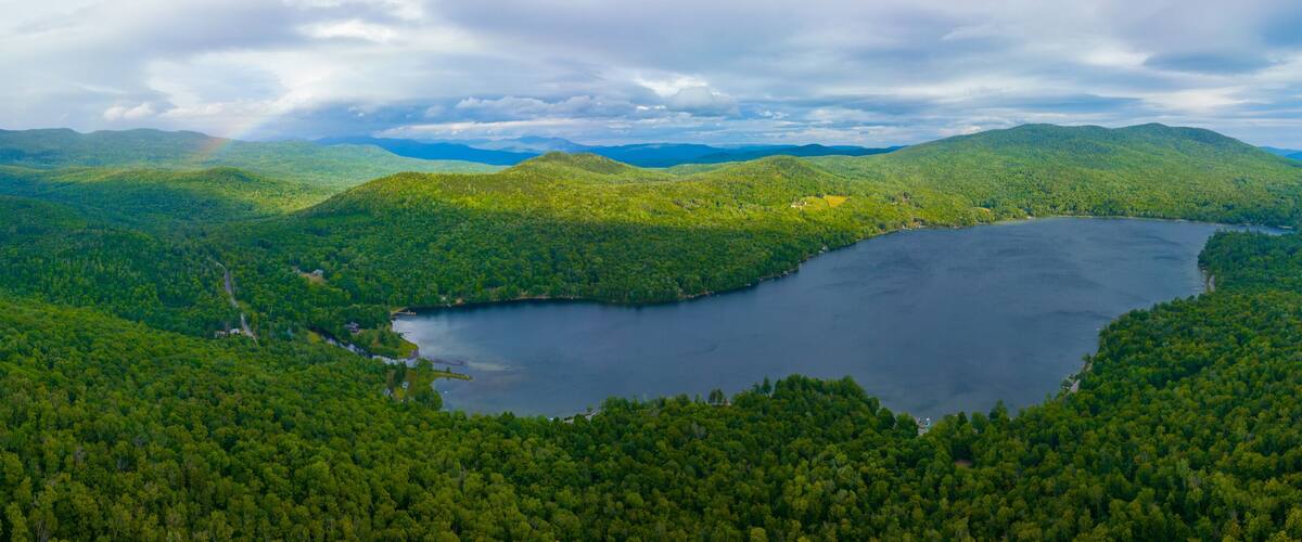 A lake surrounded by dense forest and mountains.