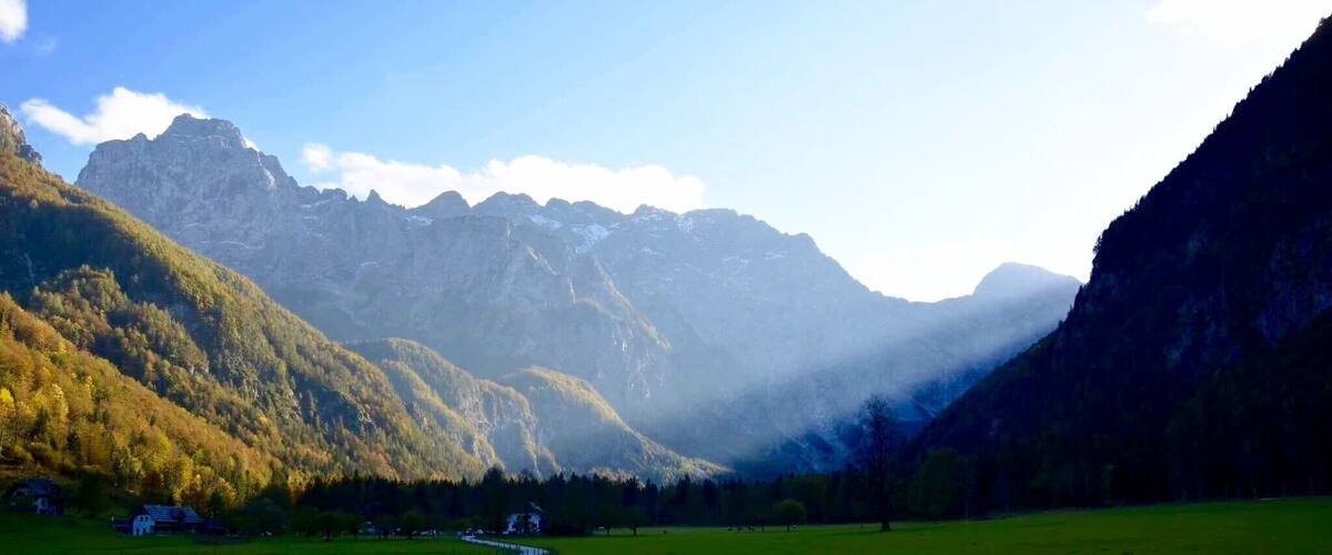 A winding road through a valley with mountains in the background.