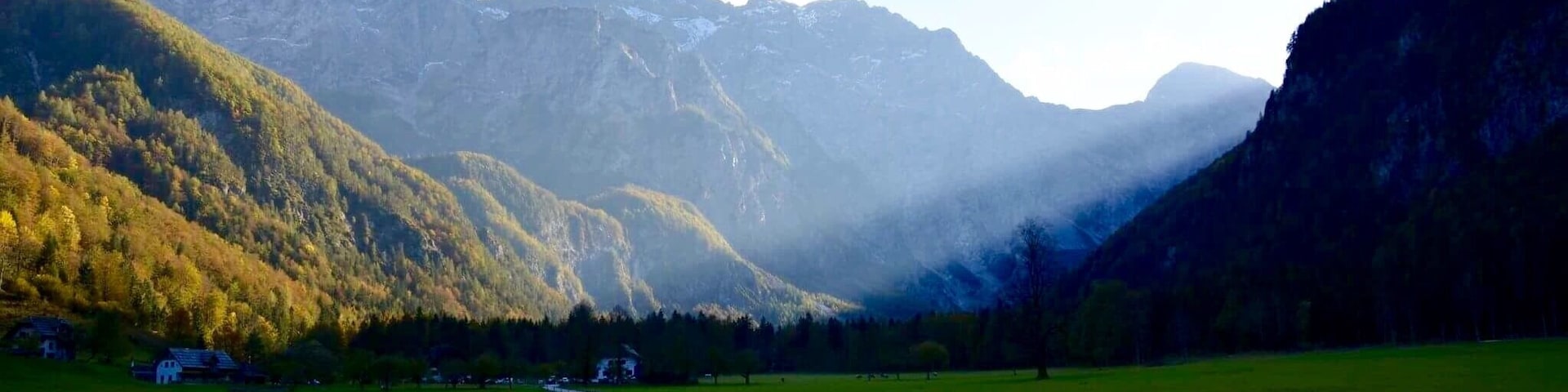 A winding road through a valley with mountains in the background.