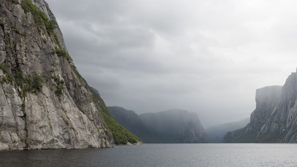 A fjord with steep cliffs and a calm sea.