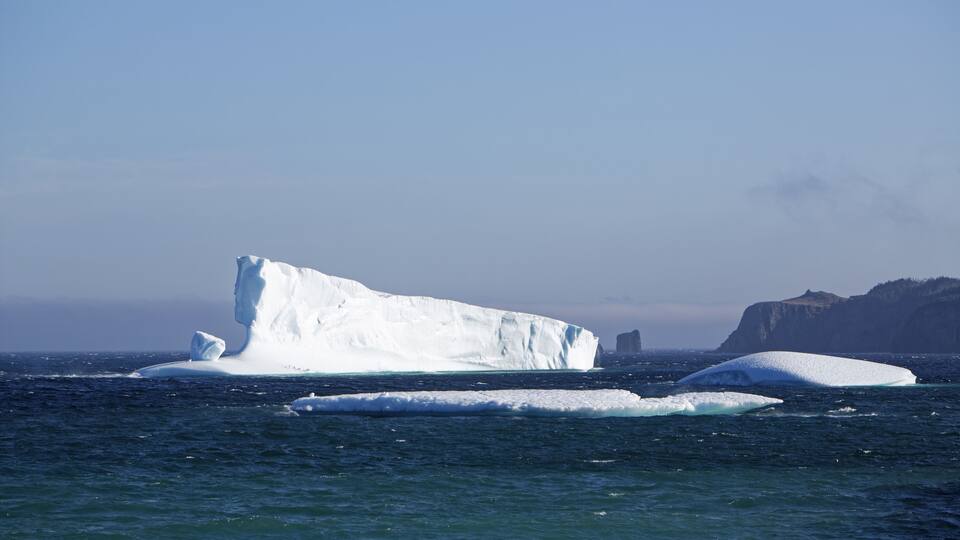 An iceberg grounded Port Rexton, Newfoundland, showing the beauty of the coastline in summer.