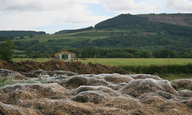 Cobwebs on a Manure Heap Just off Easby Lane the farmer has dump a load of manure ready for spreading over the fields. A film of spiders' webs covers the whole heap shimmering gently in the morning breeze. The barn is new and in the distance is Easby Moor with Captain Cook's Monument just off to the right.