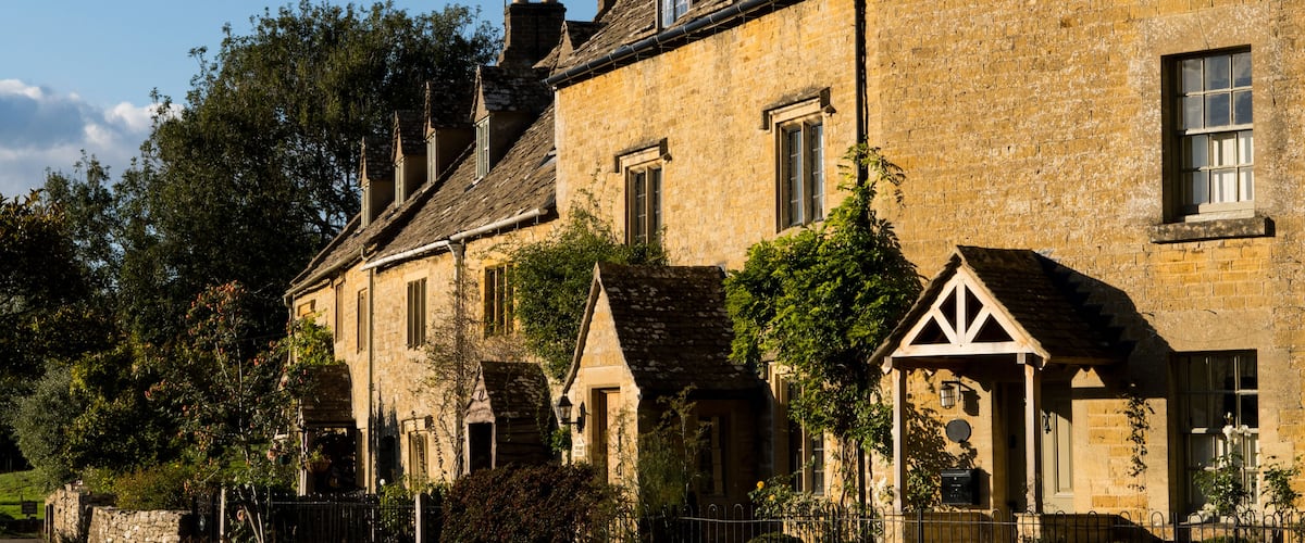 A row of traditional stone houses with pitched roofs and chimneys.