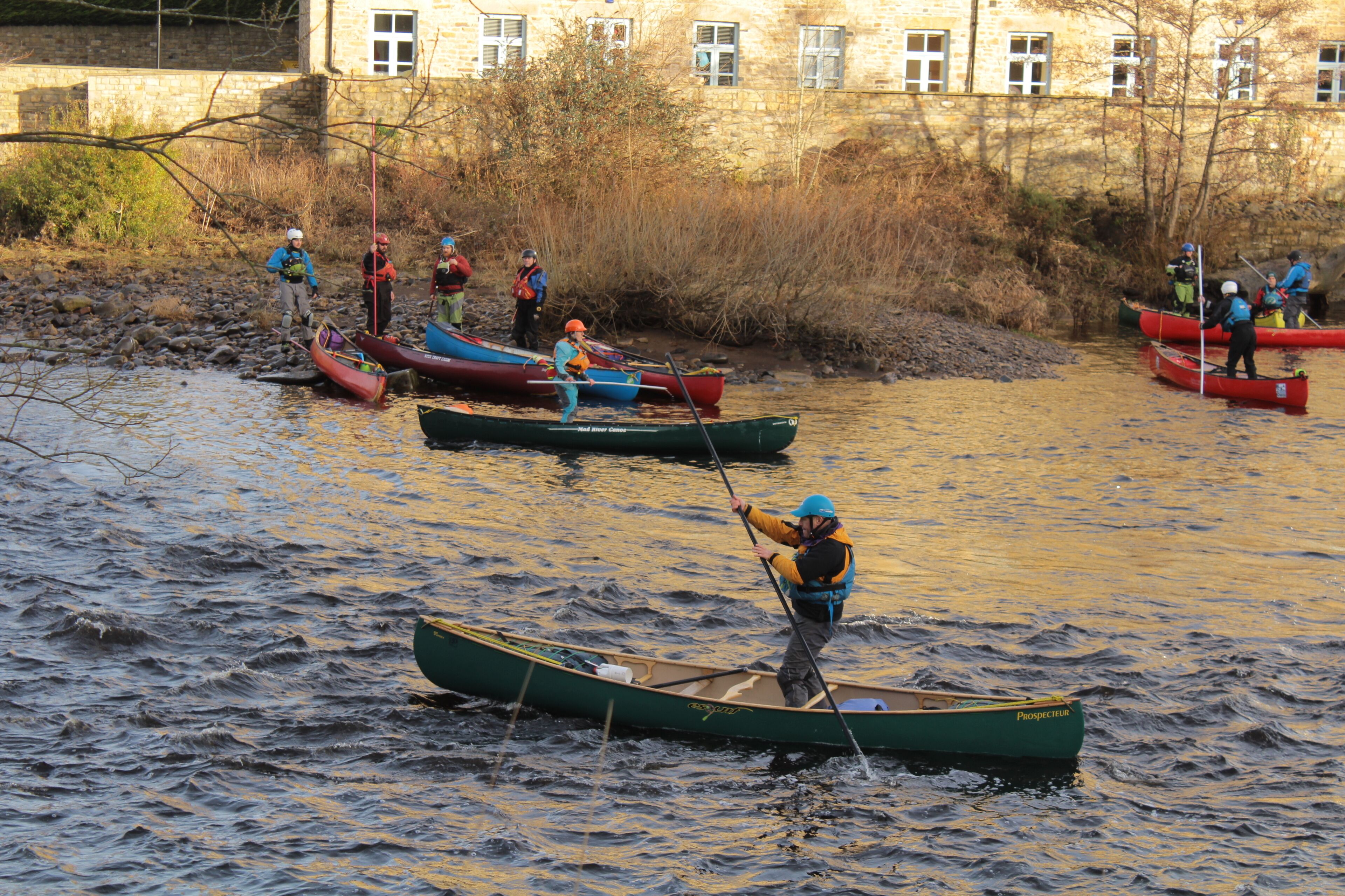 A group of people in canoes on a river.