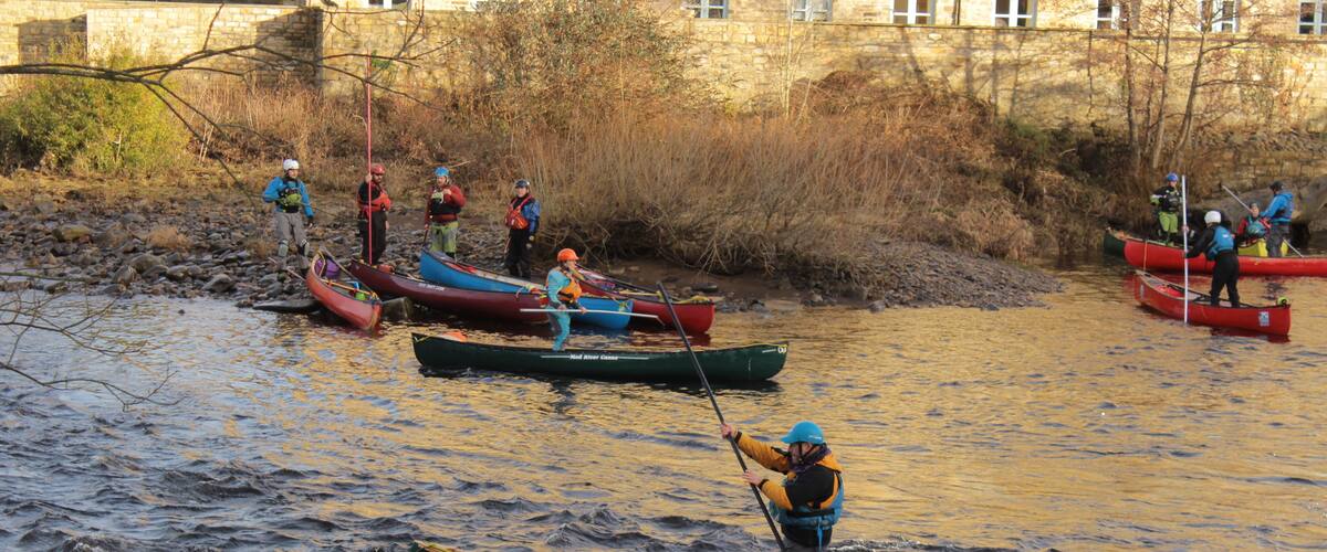 A group of people in canoes on a river.