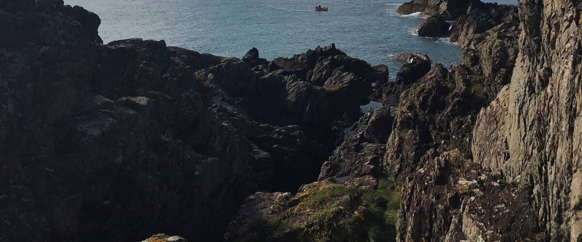 A rocky coastline with a clear sky and calm sea.