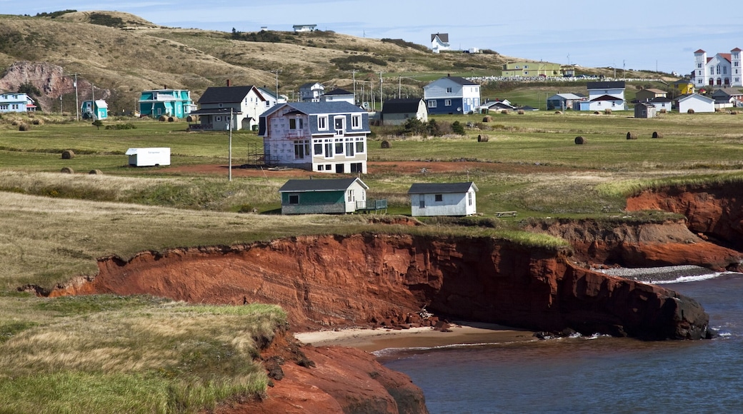 Scalloped red sandstone cliffs with houses perched on the top on the island of Havre-Aubert, Iles de la Madeleine (Magdalen Islands), Quebec, Canada