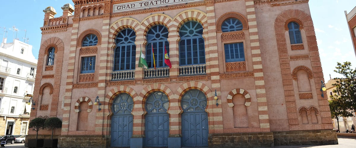 A historic building with arched windows and a sign reading "GRAN TEATRO FALLA".